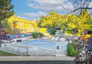 View of swimming pool and tennis courts from Primary Bedroom Deck