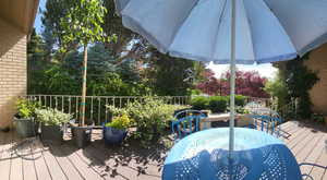 View of front entry wooden deck from sliding glass door entry to level 1, and landscaping