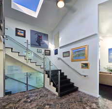 Stairs from front door entry with a skylight