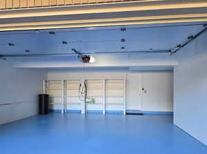 Garage featuring a garage door opener and finished flooring