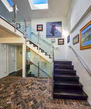 Stairs from front door entry with a skylight