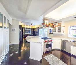 Kitchen featuring stainless steel appliances, white cabinetry, a wealth of natural light, and kitchen peninsula