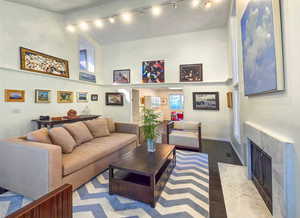 Living room with a towering ceiling and dark wood flooring, featuring a fire place