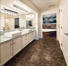 Primary Bathroom featuring double sink vanity, shower with separate jetted bathtub