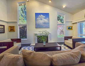 Living room featuring a premium fireplace and high vaulted ceiling