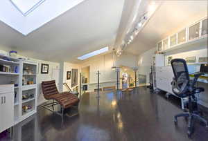 Studio / Office Space showing off track lighting, with skylights and view to the Entry and Living Room