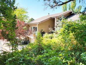 Exterior view of side of home, showing Primary Bedroom deck and entry deck