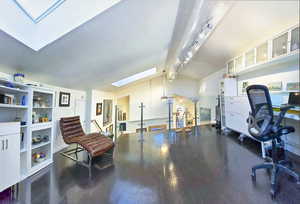 Studio / Office Space showing off track lighting, with skylights and view to the Entry and Living Room