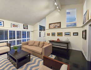 Living room with a towering ceiling and dark wood flooring, featuring a fire place