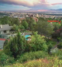 Aerial view at dusk featuring a mountain view, city view, and community ammentities of pool and tennis court