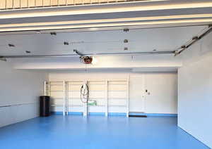 Garage featuring a garage door opener and finished flooring