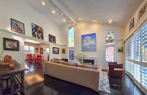 Living room with a towering ceiling and dark wood flooring, featuring a fire place