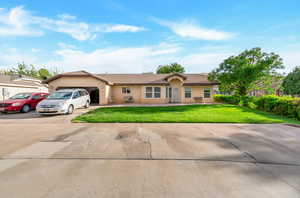 Ranch-style house with a garage and a front lawn