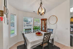 Dining room with an inviting chandelier and light tile patterned floors