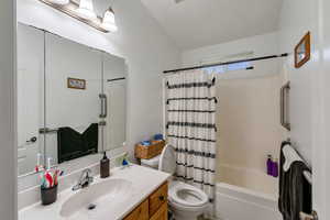 Full bathroom with vanity, toilet, and shower / bath combination with curtain