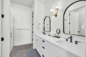 Bathroom with a shower with shower door and vanity