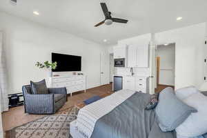 Bedroom with sink, ceiling fan, and hardwood / wood-style flooring