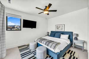 Carpeted bedroom featuring ceiling fan