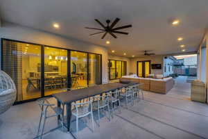 View of patio with ceiling fan and an outdoor hangout area