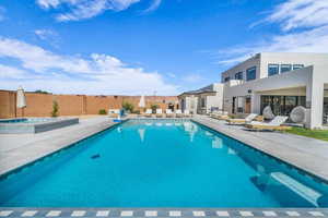 View of swimming pool with an in ground hot tub and a patio area