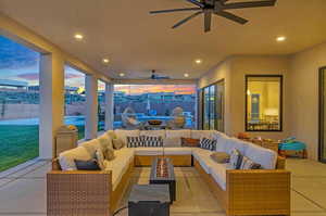 Patio terrace at dusk featuring ceiling fan and an outdoor hangout area