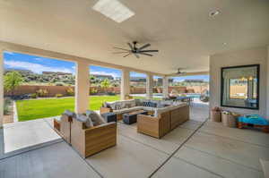 View of patio with ceiling fan and an outdoor living space