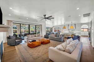 Living room with ceiling fan and hardwood / wood-style floors