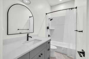 Full bathroom with shower / tub combo with curtain, vanity, toilet, and tile patterned floors