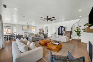 Living room with light hardwood / wood-style floors and ceiling fan