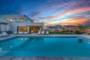 Pool at dusk featuring a patio area