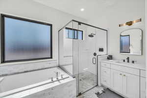 Bathroom with tile patterned flooring, independent shower and bath, and vanity