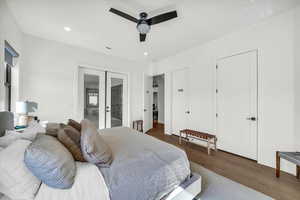 Bedroom with french doors, access to exterior, dark hardwood / wood-style flooring, and ceiling fan