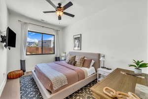 Bedroom with ceiling fan and hardwood / wood-style flooring