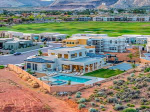 Rear view of house with a mountain view, an in ground hot tub, and a patio area