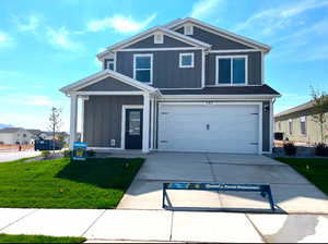 View of front of property with central AC unit, a garage, and a front lawn