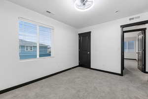 Unfurnished bedroom featuring light carpet