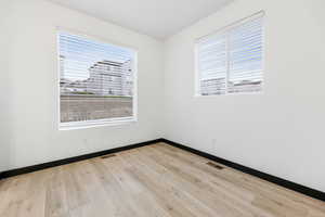 Spare room featuring light hardwood / wood-style flooring and a wealth of natural light