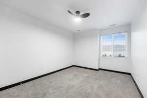 Carpeted spare room with ceiling fan