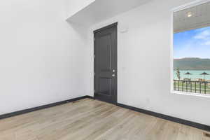 Empty room featuring light hardwood / wood-style floors and a water view