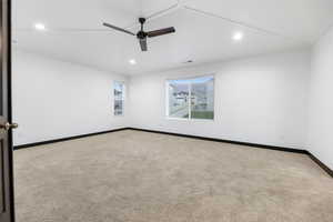 Spare room featuring vaulted ceiling and carpet