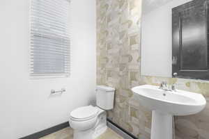 Bathroom featuring sink, toilet, and hardwood / wood-style flooring