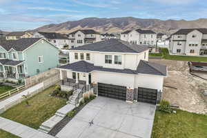 View of front facade with a mountain view, a garage, and a front lawn