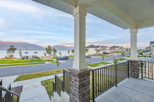 Balcony featuring a water and mountain view and a porch