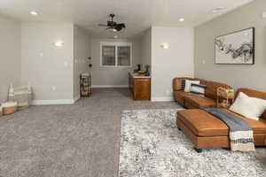 Living room featuring ceiling fan and light carpet