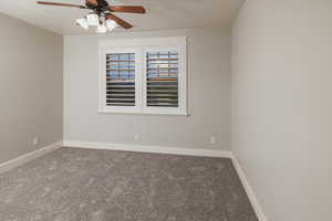 Carpeted empty room with ceiling fan