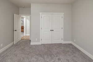 Unfurnished bedroom featuring a closet and carpet floors