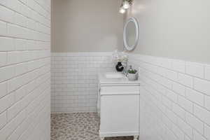 Bathroom with vanity and tile walls