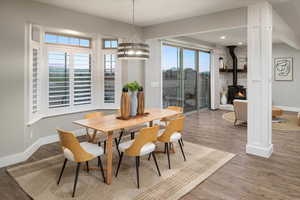 Dining space with a chandelier, hardwood / wood-style floors, and a wood stove