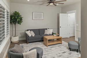 Living room with ceiling fan and hardwood / wood-style floors