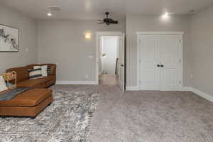 Living area with ceiling fan and carpet flooring